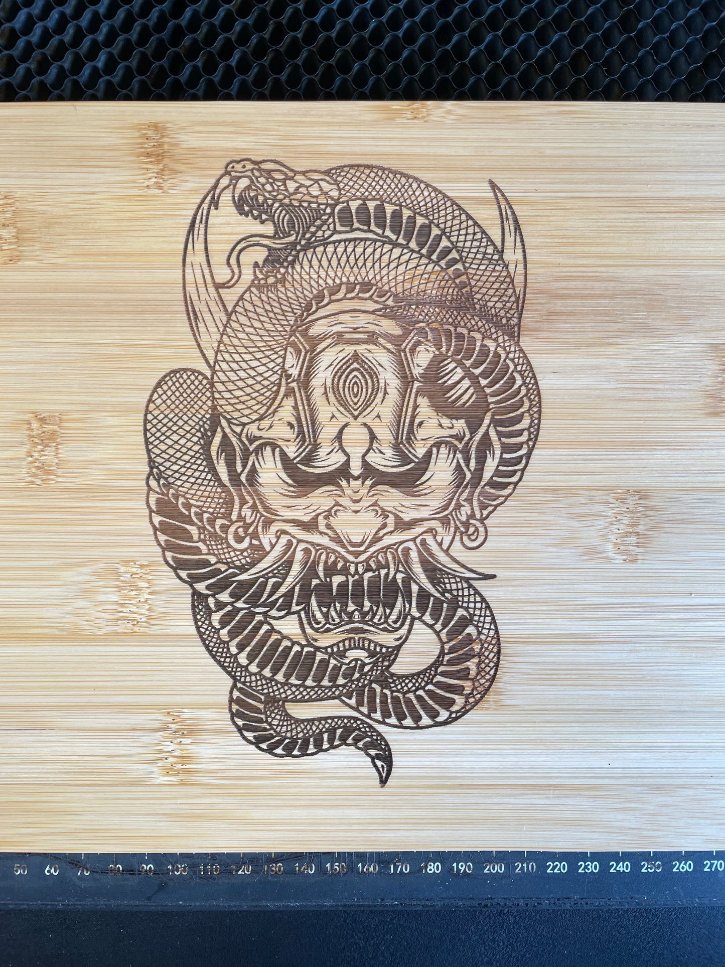Samurai mask with snake laser engraved bamboo cutting board.