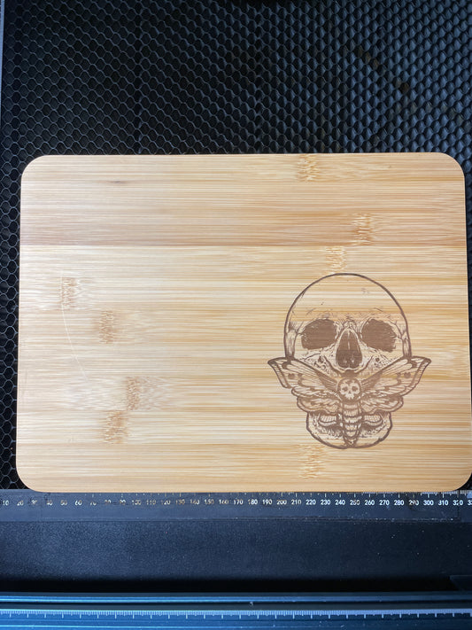 Death head moth and skull laser engraved bamboo cutting board.